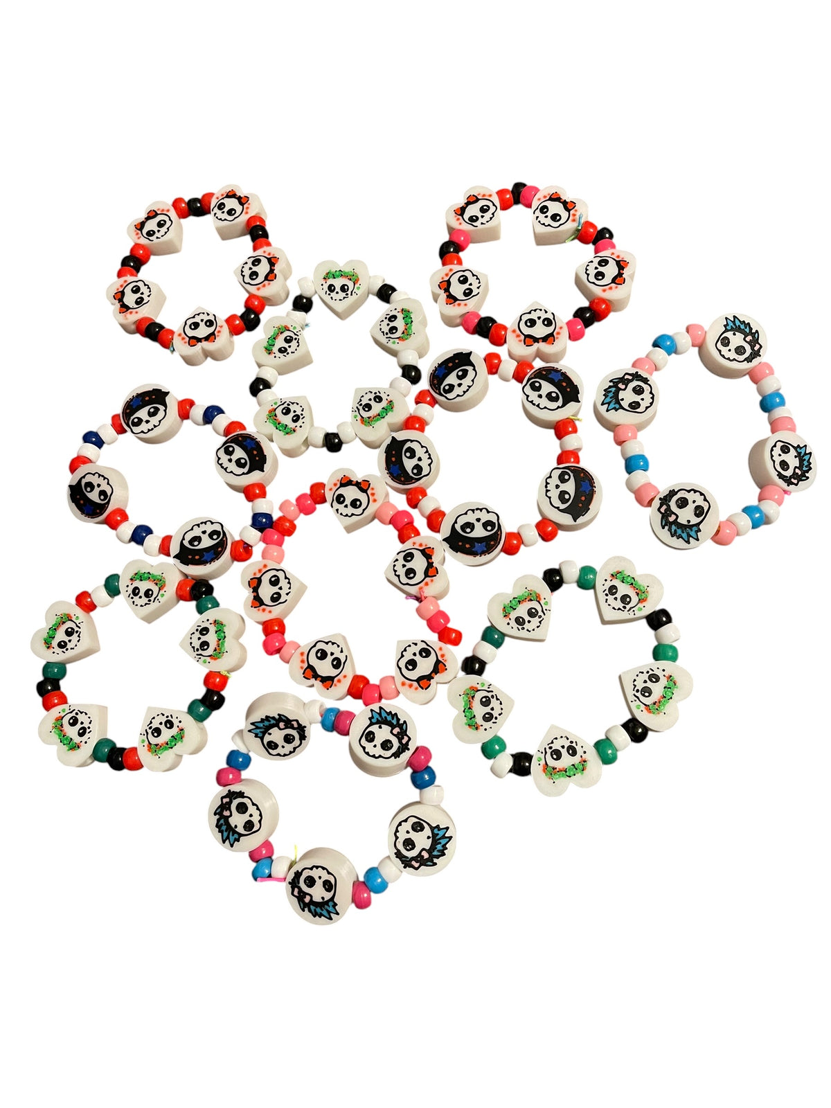 A collection of colorful 3d printed beaded bracelets with white skull-shaped charms, arranged on a plain white background.