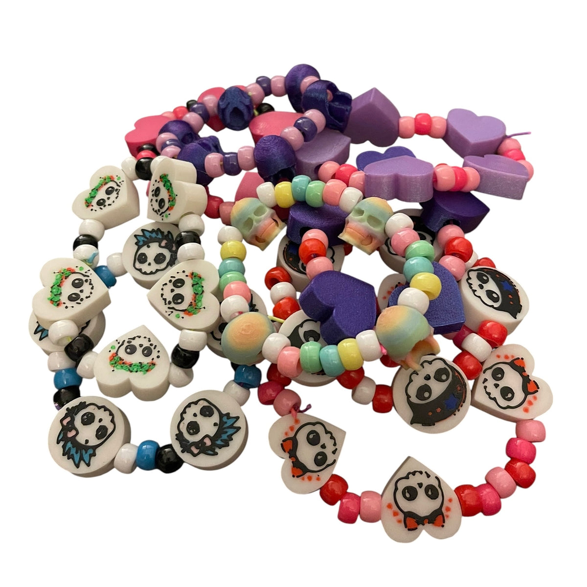A set of colorful beaded bracelets featuring sugar skull designs and heart, skull, and round beads in multiple vibrant colors, arranged on a plain white background.