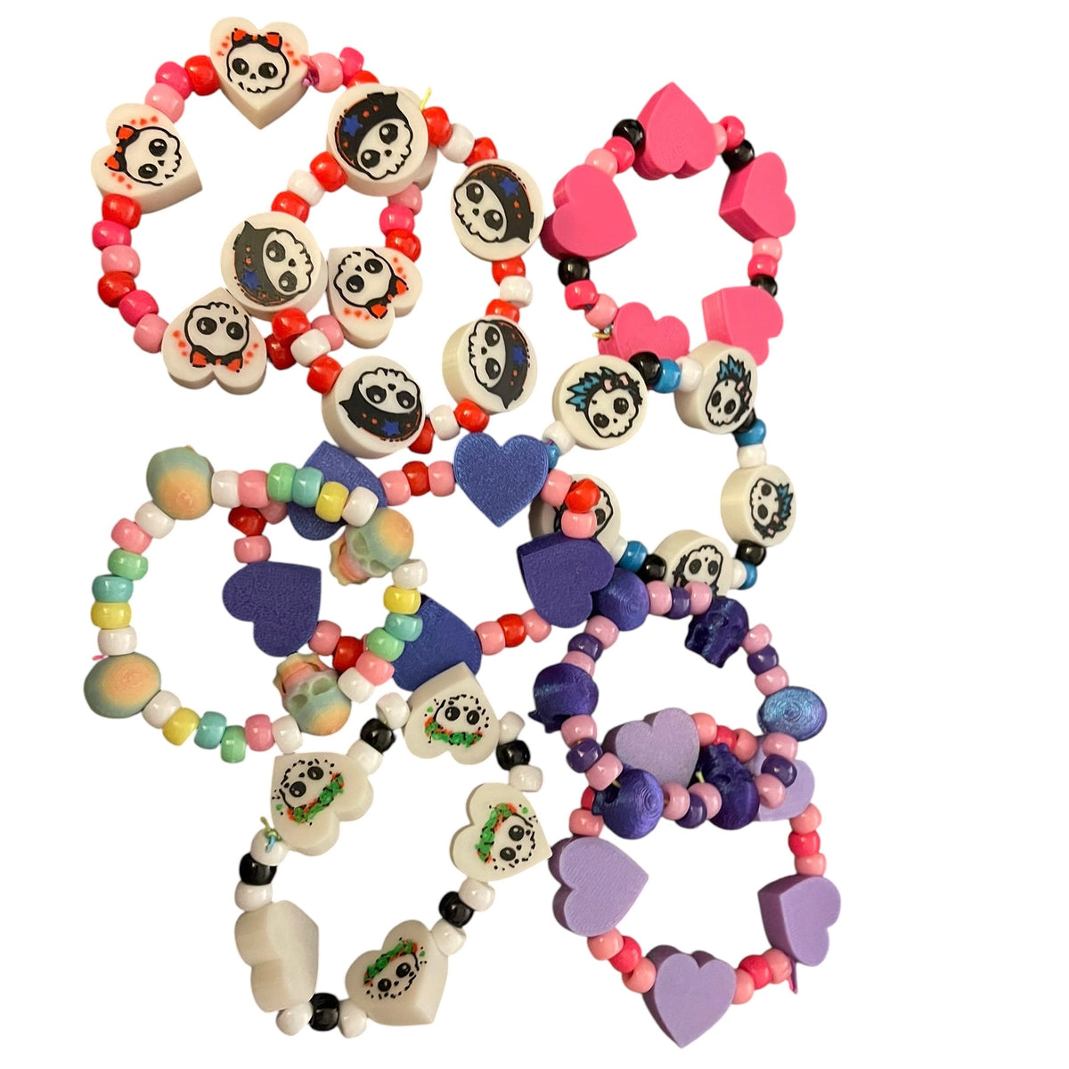 A set of colorful beaded bracelets with 3d printed  skull and heart charms, displayed on a clean white background.