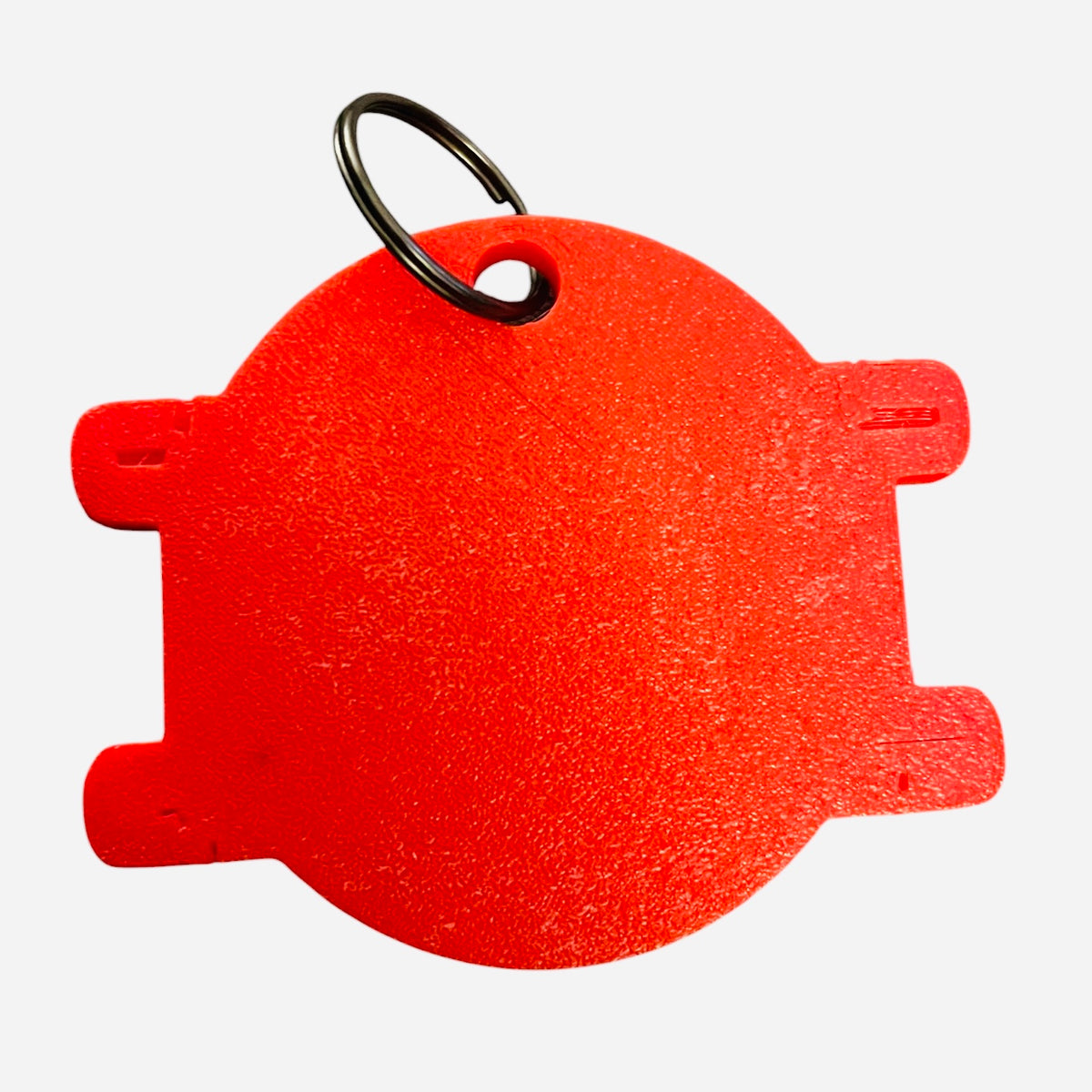 A bright red textured plastic key tag with a black metal split ring, shown against a plain white background.
