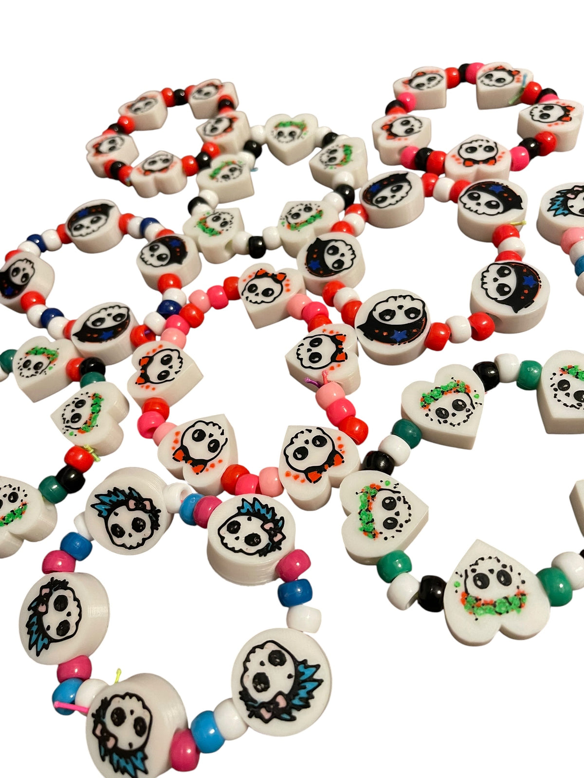 A collection of colorful 3d printed  beaded bracelets featuring cute white skull beads, displayed on a clean white background.