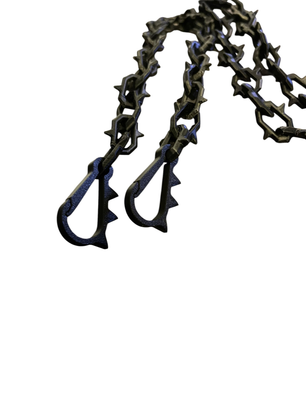 A close-up of a black 3d printed chain with spikey links and two matching custom printed carabiner-style hooks, isolated on a plain white background.