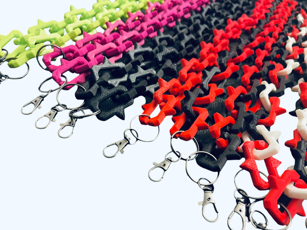 Many color examples of plastic keychain lanyards with interlocking studded links and gun metal color lobster clasp rings, shown on a plain white background.