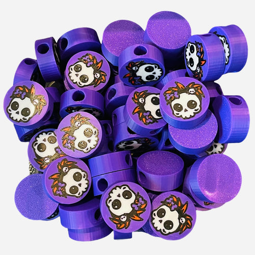 Purple round beads with girly skull design with red hair and a purple bow. 