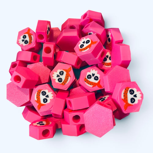 Pink hexagonal beads with girly skull design with a red bandana.